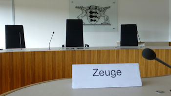Bild zeigt einen Blick in den Sitzungssaal des Landesarbeitsgerichts Baden-Württemberg und im Hintergrund das Landeswappen